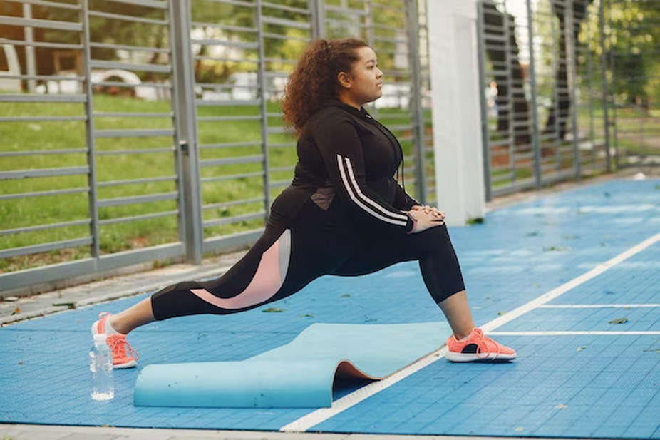 woman exercising in yoga pants and a sweatshirt.